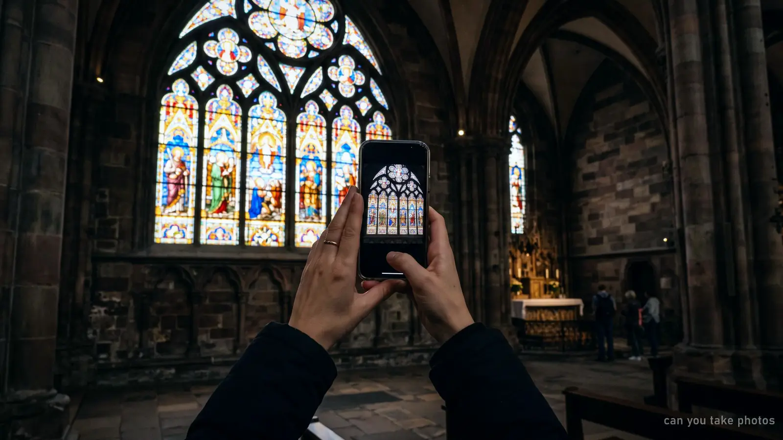 Illustration of a visitor photographing a Gothic stained-glass window with a phone